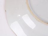 a white plate with a gold rim sitting on a table