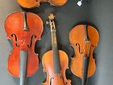 three old violin ' s hanging on a wall in a room