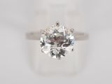 a close up of a diamond ring on a white surface