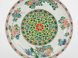 une assiette chinoise ornée de fleurs et de feuilles sur fond blanc