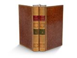 un vieux livre contenant deux autres livres, posé sur une surface blanche
