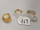 trois bagues en or et une bague en diamant posées sur un fond blanc