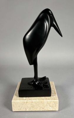 sculpture représentant un oiseau noir sur un socle en marbre, sur fond gris