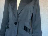 un blazer gris à revers noirs sur un mannequin de couture