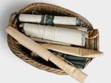a wicker basket filled with rolled up papers and a roll of paper