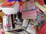 une pile de livres sur un lit recouvert d'une couverture rouge