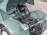 a small green car with an engine in the trunk