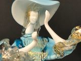a figurine of a woman holding a bird in her hand
