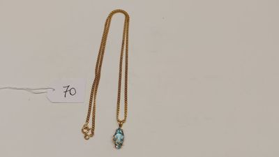un collier en or orné d'une topaze bleue et d'une chaîne en or