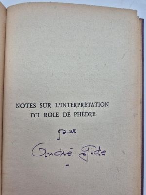 un livre ouvert, sur lequel figure un titre écrit à la main, posé sur une table