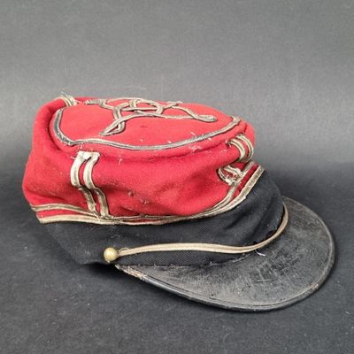 un chapeau rouge et noir posé sur une table noire