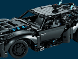 a lego model of a black car with a blue background