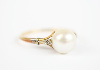 a close up of a pearl ring on a white surface