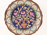 a decorative plate with a vase on it on a white background