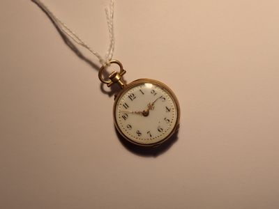 une montre de poche en or avec une chaîne, posée sur une surface blanche