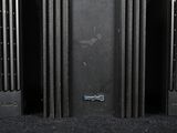 three black speakers that are sitting in a room