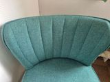 a blue chair that is next to a white wall