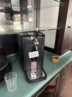 a coffee machine sitting on a counter with a cup on it