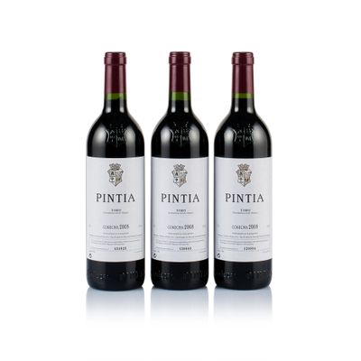 three bottles of wine sitting next to each other on a white surface