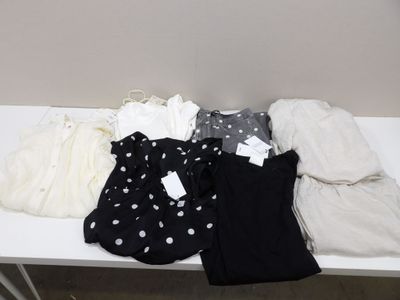 une table blanche recouverte d'une multitude de vêtements
