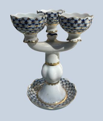a white and blue bowl and two bowls on a stand