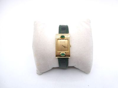 une photo d'une montre-bracelet en or avec un bracelet vert