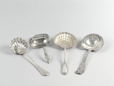 five silver spoons and a spoon with a shell on them