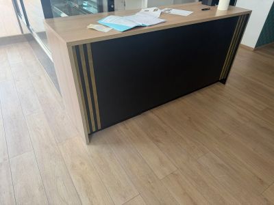 a black and gold desk in an office with a large window