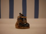 a small figurine of a cat sitting on a rock