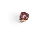 a close up of a ring with a red stone on it