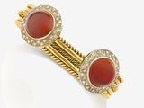 a close up of a pair of gold and coral bracelets