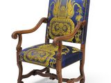 a blue and gold upholstered chair with a wooden frame
