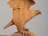 sculpture of an eagle on a wooden base on a table