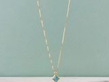 un collier à chaîne en or orné d'un pendentif en pierre bleue