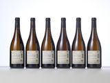 six bottles of wine are lined up in a row on a table