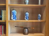 a book shelf with books and vases on top of it