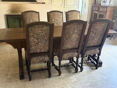 six chairs around a table in the middle of a room