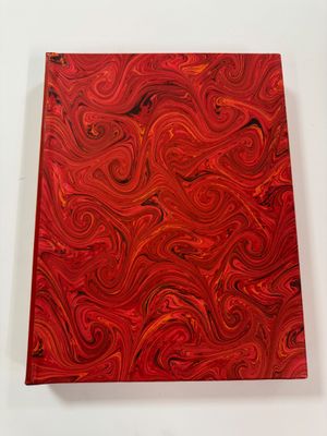a close up of a red book with a swirl pattern on it