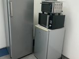 a silver refrigerator and a black and white machine in a room