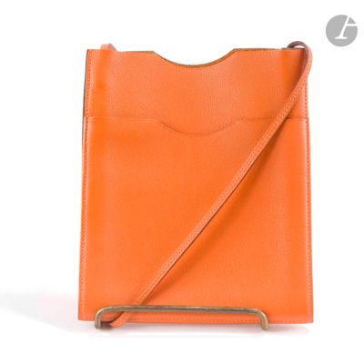 un sac à main orange muni d'une bandoulière, sur fond blanc