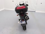 a motorcycle that is parked in a room with a white wall
