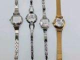 three watches are sitting next to each other on a white surface