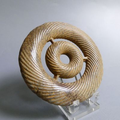 a sculpture of a spiral shaped object on a clear stand