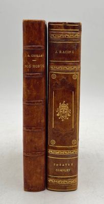 two old books sitting on top of each other on a white surface