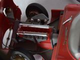 a close up of a red toy car with a wheel