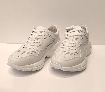 les baskets blanches sont posées sur une surface blanche, avec un fond blanc