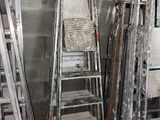 de nombreuses échelles appuyées contre un mur dans une pièce
