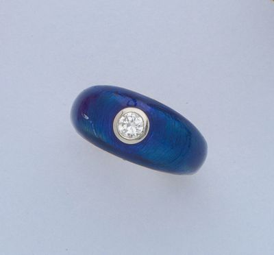 un gros plan d'une bague bleue ornée d'un diamant au centre