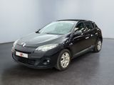 La voiture noire est garée dans une grande pièce au sol noir.