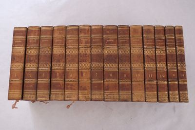 six vieux livres empilés sur une surface blanche